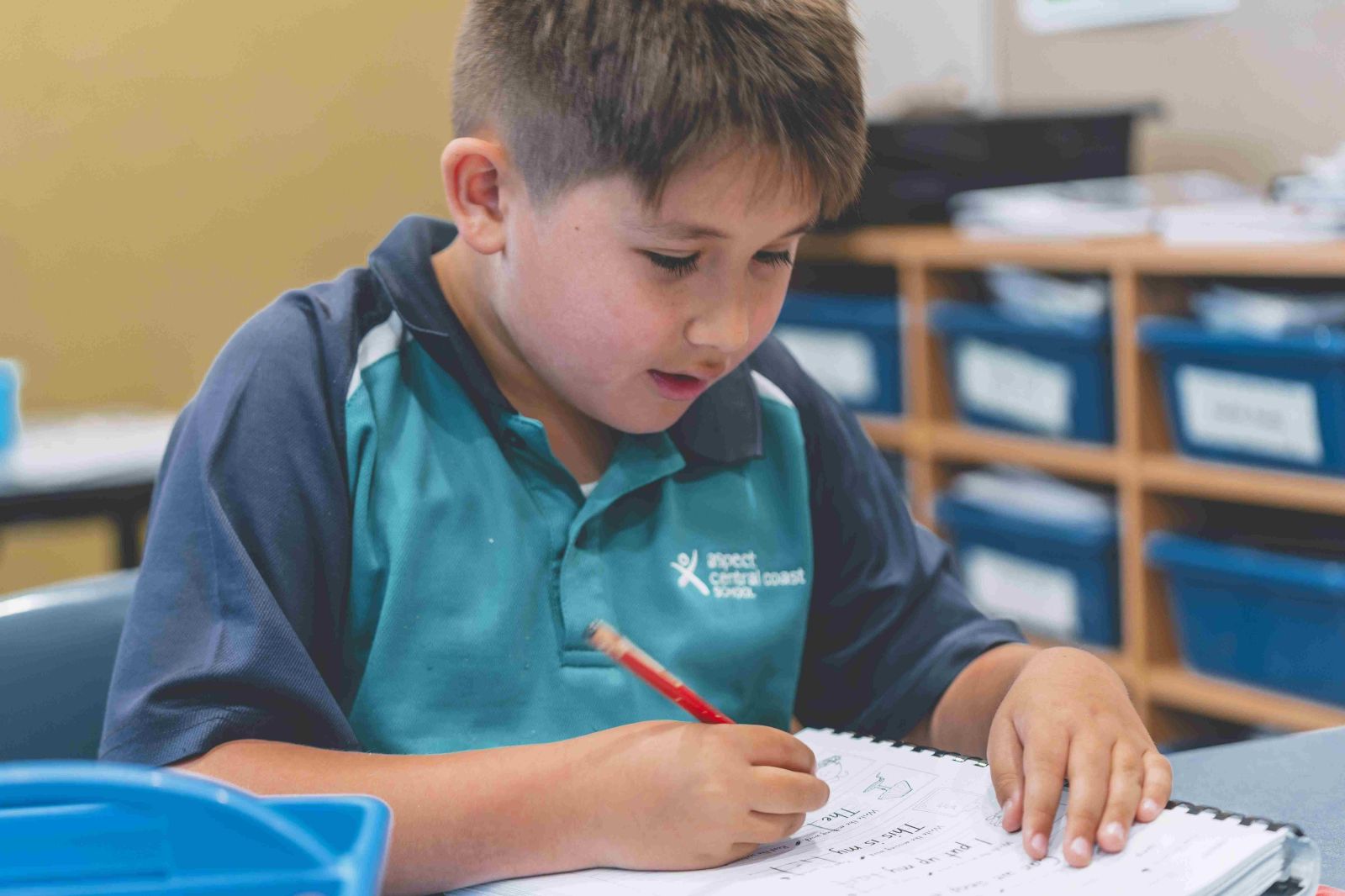 Student focused on writing during classroom learning activity